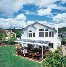 Photo of a home with a solar electric systems integrated into an awning over a back porch.