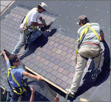 Photo of workers installing PV shingles directly on to a roof.